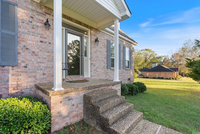 view of exterior entry with a lawn