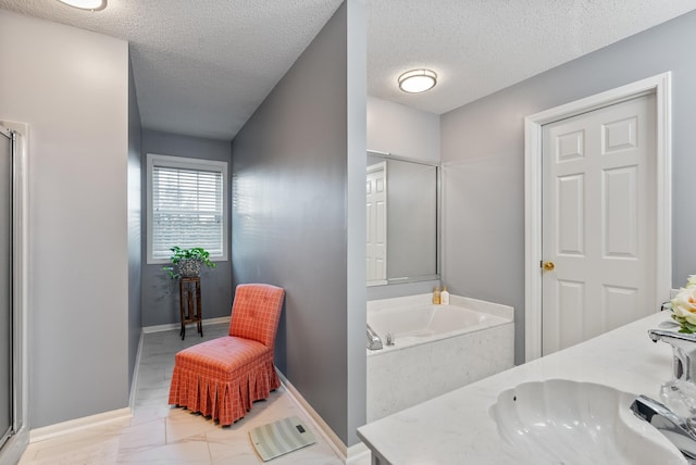 bathroom with separate shower and tub, vanity, and a textured ceiling