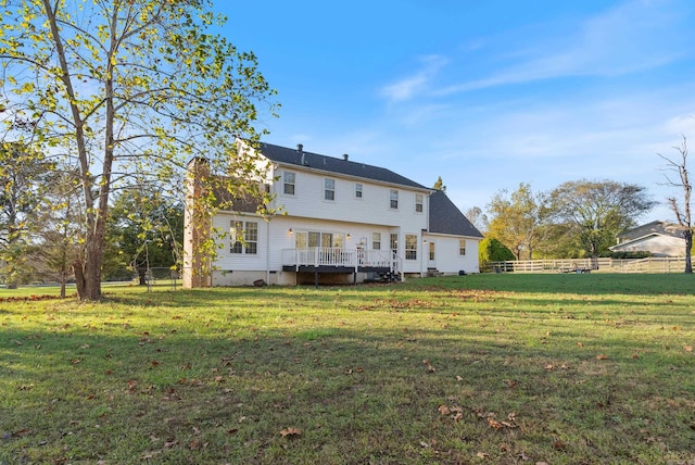 rear view of property with a deck and a yard