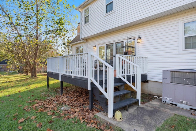 view of property exterior with central AC, a deck, and a lawn