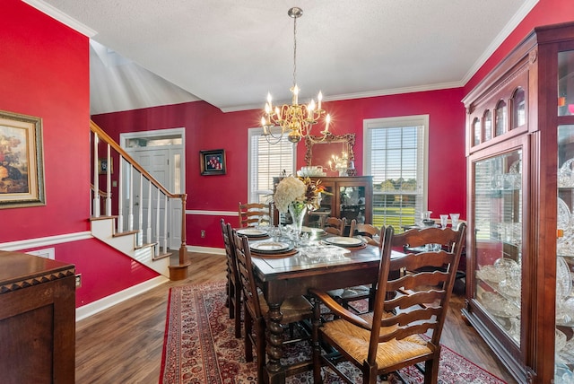 dining room with a textured ceiling, a chandelier, dark hardwood / wood-style floors, and ornamental molding