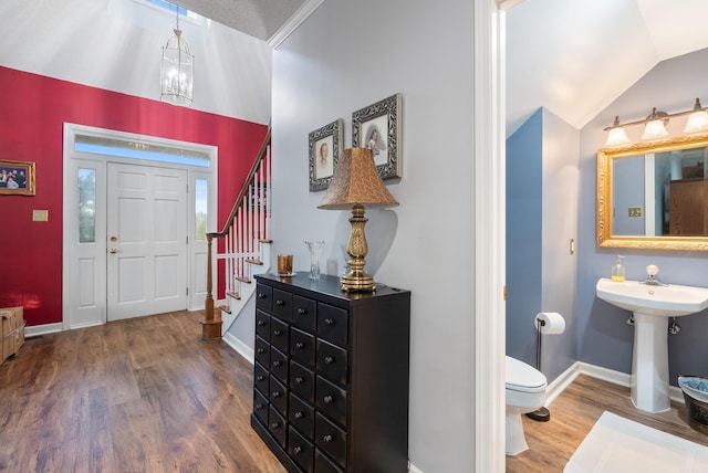 foyer entrance featuring hardwood / wood-style flooring, vaulted ceiling, and sink