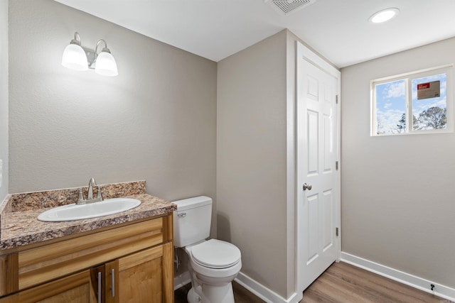 bathroom featuring hardwood / wood-style floors, vanity, and toilet