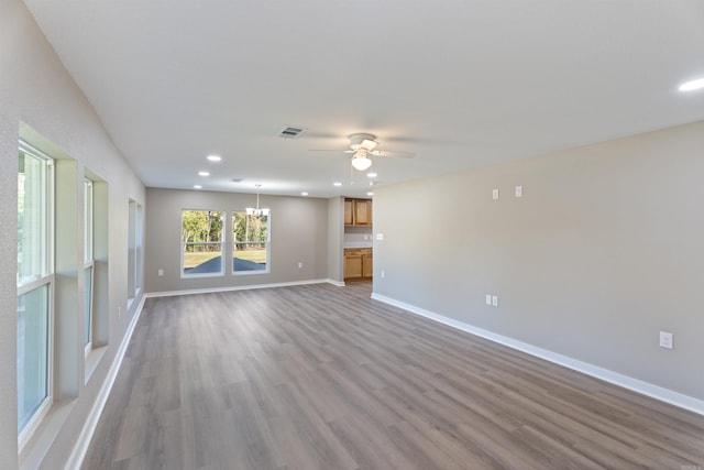 unfurnished living room with light hardwood / wood-style flooring and ceiling fan with notable chandelier