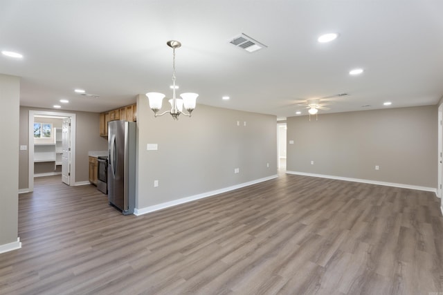 kitchen featuring ceiling fan with notable chandelier, light wood-type flooring, stainless steel appliances, and hanging light fixtures