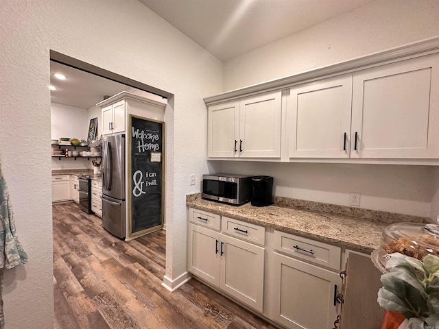 kitchen with dark hardwood / wood-style floors, light stone countertops, and appliances with stainless steel finishes