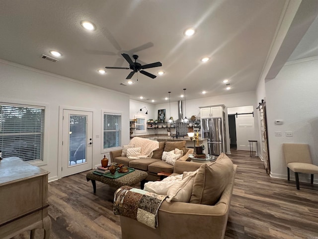 living room featuring a barn door, ceiling fan, and dark hardwood / wood-style floors