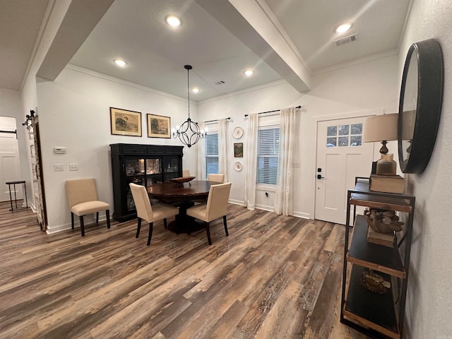 dining area featuring a barn door, ornamental molding, beamed ceiling, dark hardwood / wood-style flooring, and a chandelier