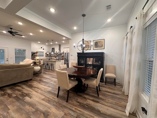 dining space with ceiling fan with notable chandelier, dark hardwood / wood-style floors, and ornamental molding