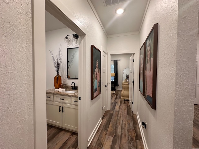 corridor featuring sink, dark hardwood / wood-style floors, and ornamental molding