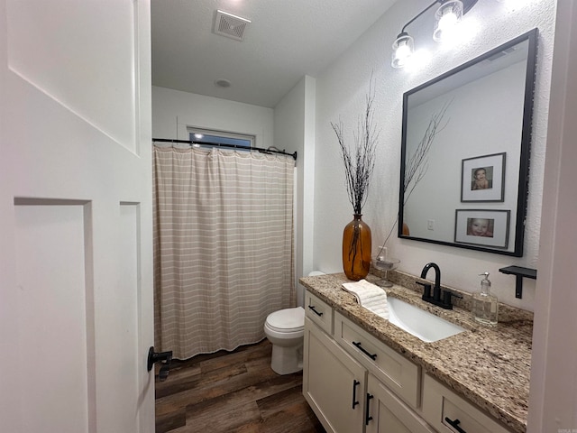 bathroom featuring vanity, hardwood / wood-style flooring, a shower with shower curtain, toilet, and a textured ceiling