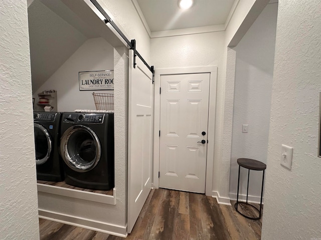 laundry area featuring a barn door, washer and clothes dryer, and dark wood-type flooring