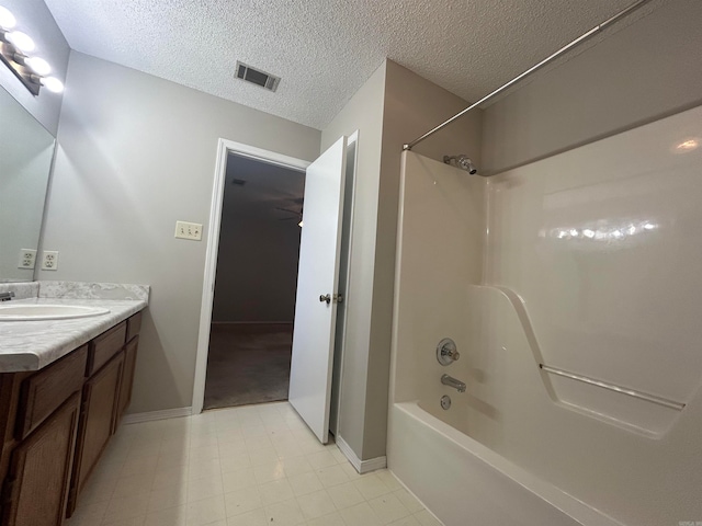 bathroom with vanity, bathtub / shower combination, and a textured ceiling