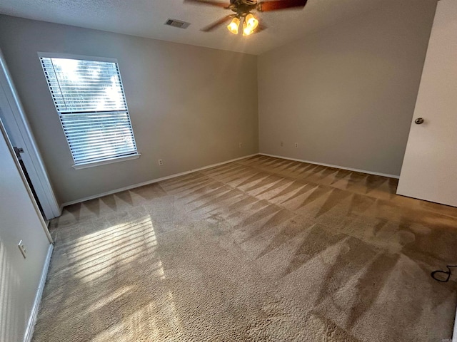 carpeted empty room featuring a textured ceiling and ceiling fan