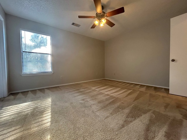 carpeted spare room featuring ceiling fan and a textured ceiling