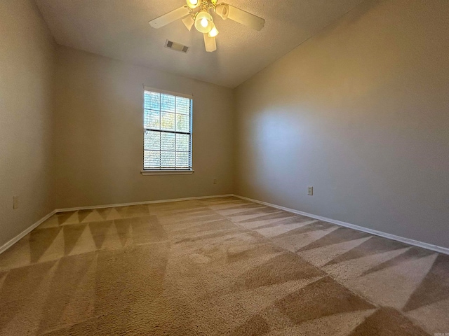 unfurnished room featuring carpet, a textured ceiling, ceiling fan, and lofted ceiling