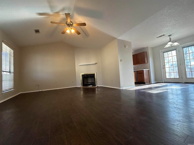 unfurnished living room featuring dark hardwood / wood-style floors, ceiling fan, lofted ceiling, and a textured ceiling