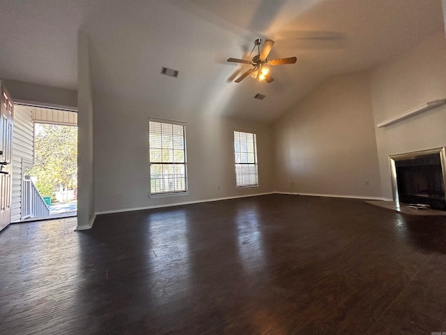 unfurnished living room featuring a wealth of natural light, dark hardwood / wood-style flooring, ceiling fan, and vaulted ceiling