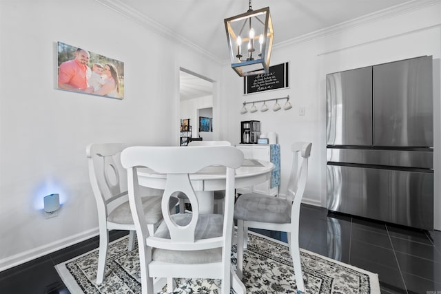 dining area featuring a chandelier, dark tile patterned floors, and ornamental molding