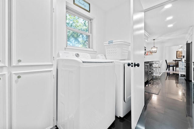 clothes washing area featuring dark tile patterned floors and separate washer and dryer