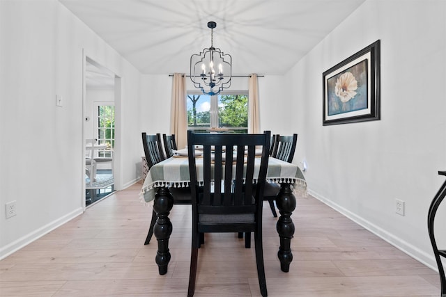 dining space featuring plenty of natural light, a notable chandelier, and light wood-type flooring