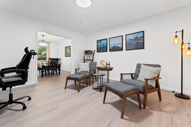 living area with a notable chandelier and light wood-type flooring