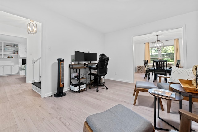 home office featuring light hardwood / wood-style floors and an inviting chandelier