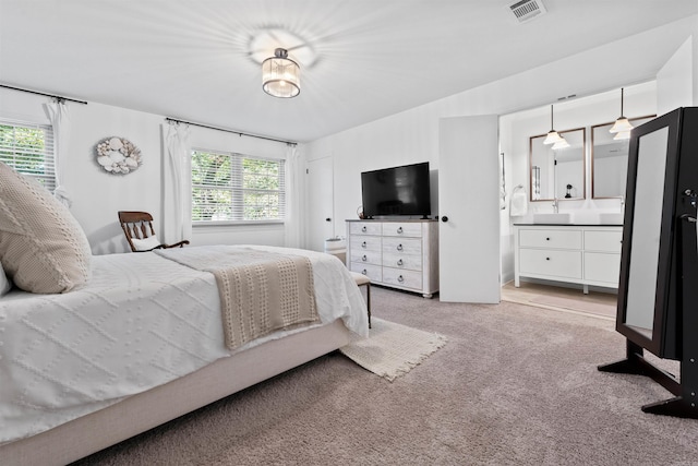 bedroom featuring light colored carpet, connected bathroom, and multiple windows