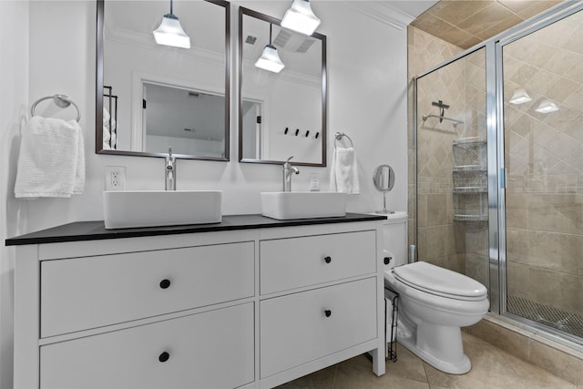 bathroom with tile patterned floors, vanity, crown molding, toilet, and a shower with shower door