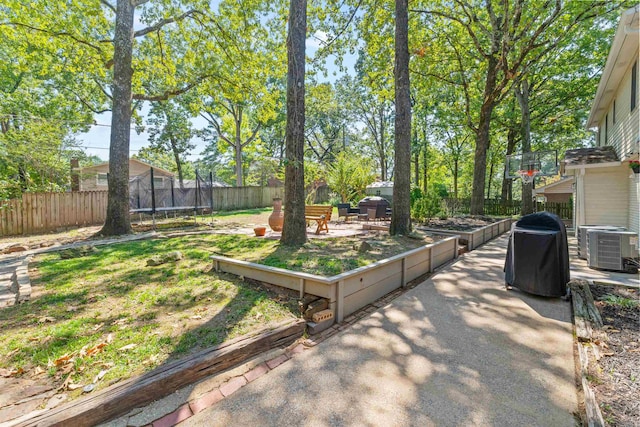 view of yard featuring cooling unit, a patio, and a trampoline