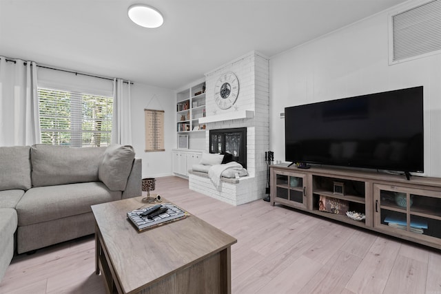 living room with a fireplace and light wood-type flooring