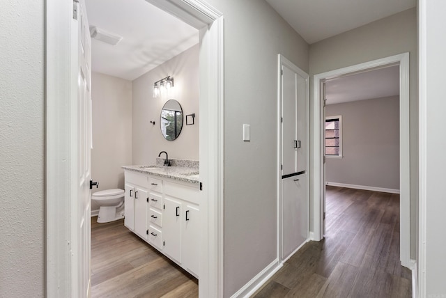 bathroom featuring hardwood / wood-style floors, vanity, and toilet