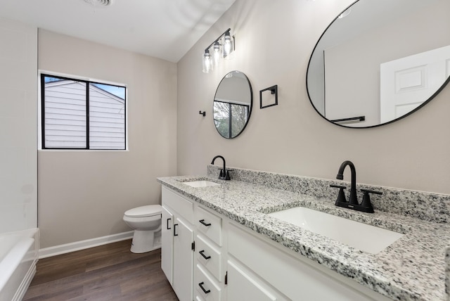 bathroom with hardwood / wood-style floors, vanity, and toilet