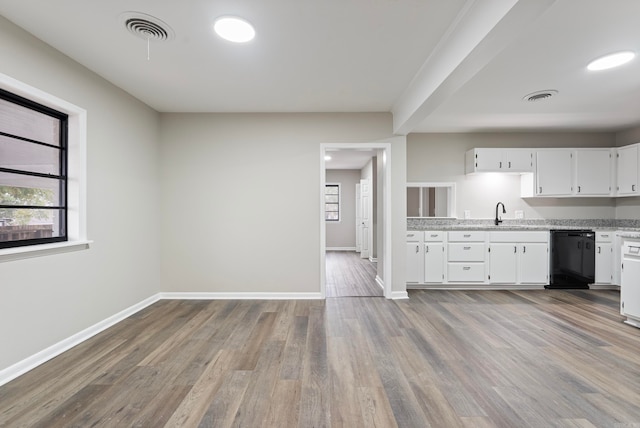 kitchen featuring light wood-type flooring, black dishwasher, and white cabinets