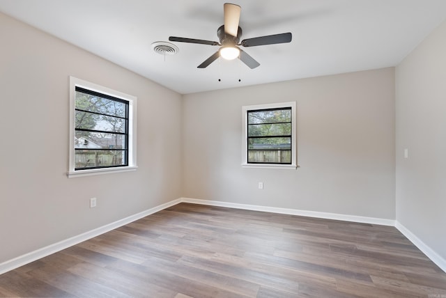 spare room featuring wood-type flooring, ceiling fan, and a healthy amount of sunlight