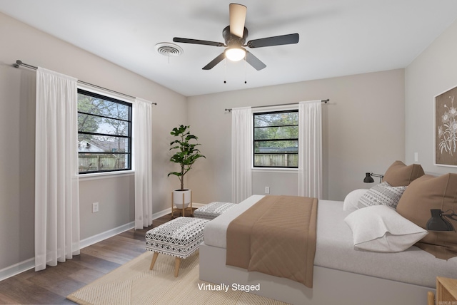 bedroom with hardwood / wood-style floors, multiple windows, and ceiling fan