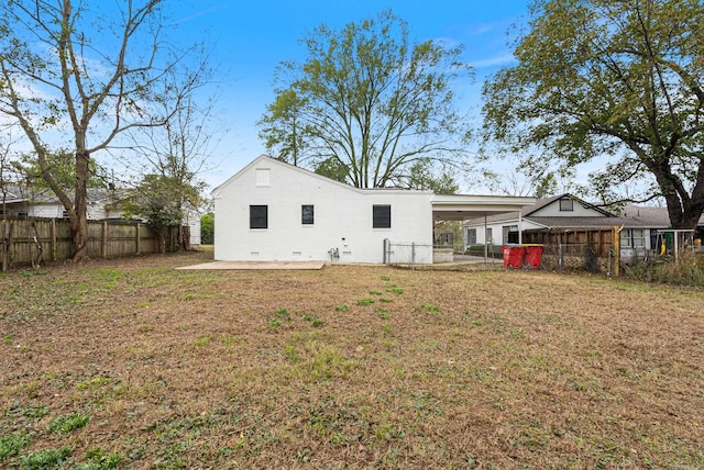 back of house with a lawn and a patio area