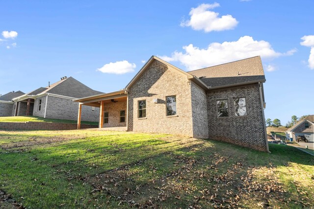 rear view of property featuring a lawn