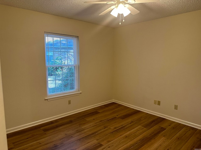 empty room featuring a textured ceiling, ceiling fan, and dark wood-type flooring