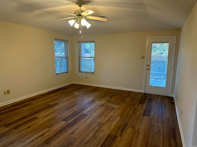 empty room with a textured ceiling, ceiling fan, and dark hardwood / wood-style floors