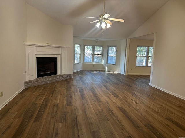 unfurnished living room with a fireplace, lofted ceiling, ceiling fan, and dark wood-type flooring