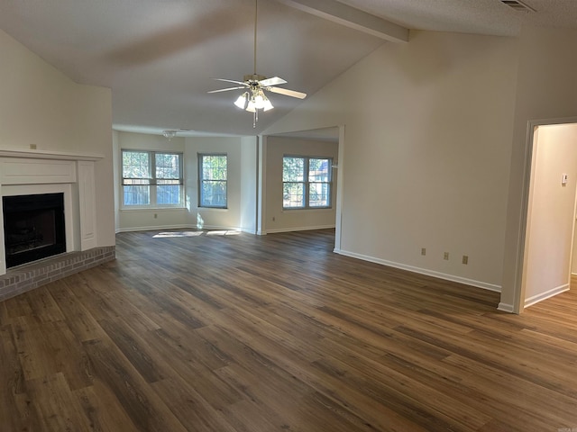 unfurnished living room featuring vaulted ceiling with beams, dark hardwood / wood-style floors, a brick fireplace, and ceiling fan