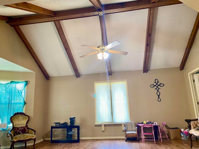 living room featuring hardwood / wood-style flooring, lofted ceiling with beams, ceiling fan, and a textured ceiling