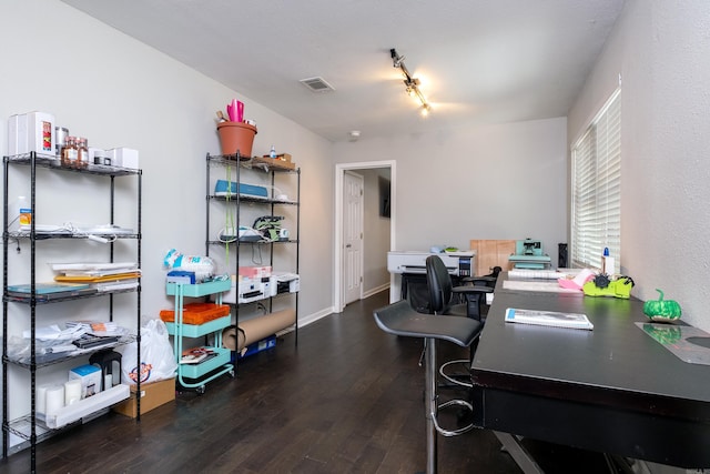 office area with dark hardwood / wood-style flooring and track lighting