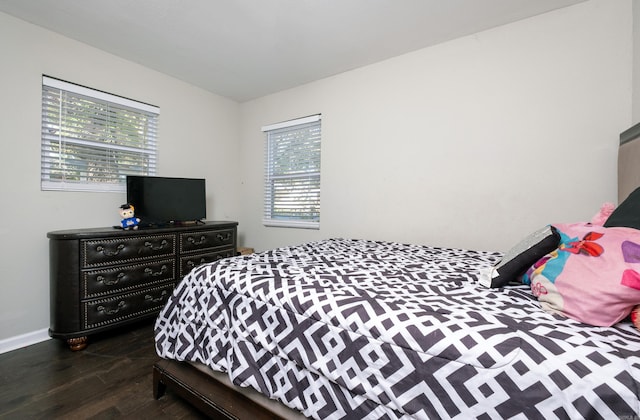 bedroom with dark hardwood / wood-style flooring