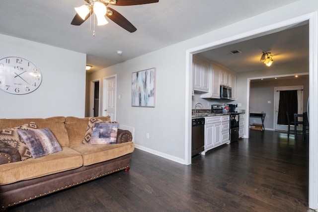 living room with ceiling fan, dark wood-type flooring, and sink