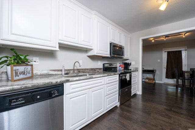 kitchen with sink, dark hardwood / wood-style floors, appliances with stainless steel finishes, light stone counters, and white cabinetry