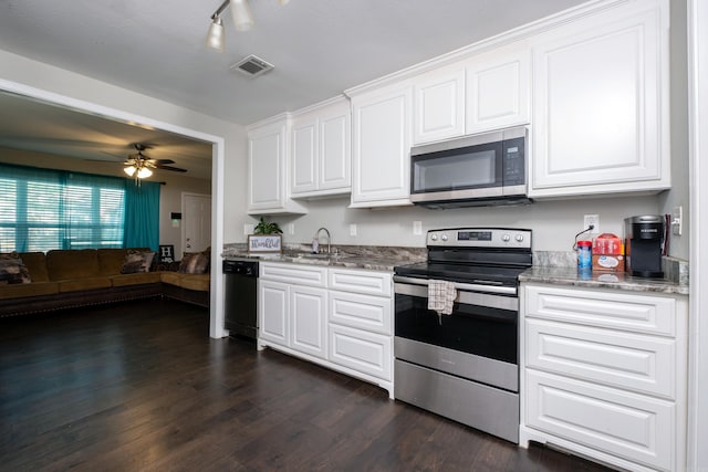 kitchen featuring dark hardwood / wood-style flooring, dark stone counters, stainless steel appliances, sink, and white cabinets