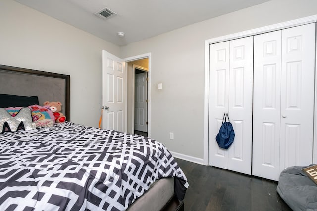 bedroom with dark hardwood / wood-style flooring and a closet