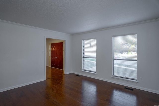 spare room with a textured ceiling, dark hardwood / wood-style flooring, and crown molding